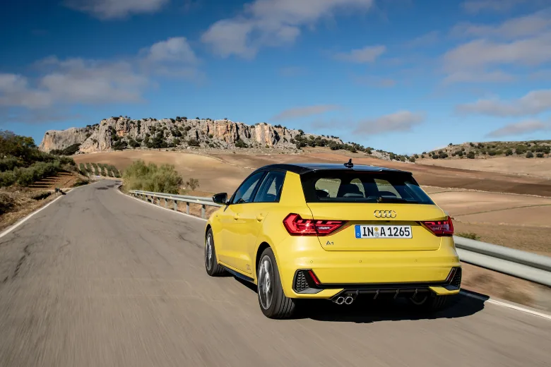 Audi A1 Sportback amarillo visto desde la parte trasera en carretera