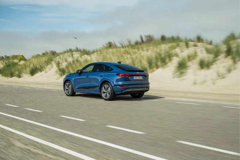 Audi Q6 Sportback e-tron azul visto desde la parte trasera en carretera