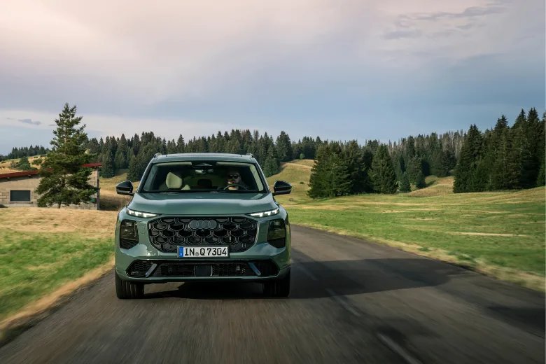 Audi Q7 verde visto de frente en conducción por carretera