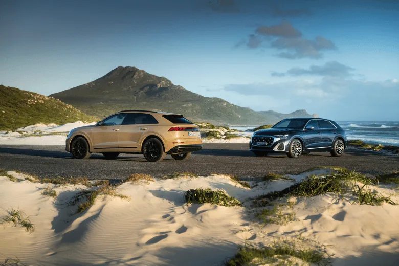 Gama Audi Q8 en color crema y azul en la playa