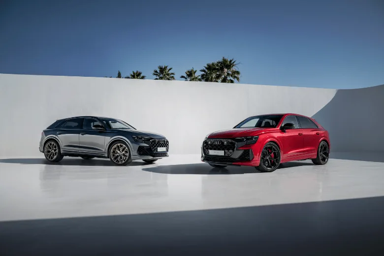 Gama Audi SQ8 en rojo y gris ante una casa