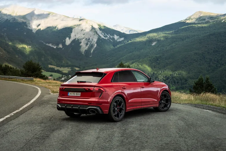 Audi RS Q8 rojo visto desde la parte trasera y lateral en carretera